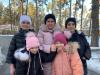 Eine Mutter und ihre vier Kinder besuchen in winterlicher Kleidung einen Park.