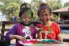 Zwei Kinder aus Nepal feiern Holi und haben sich die Gesichter geschminkt