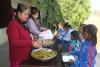 Zwei Frauen geben Essen an die Schülerschaft aus.