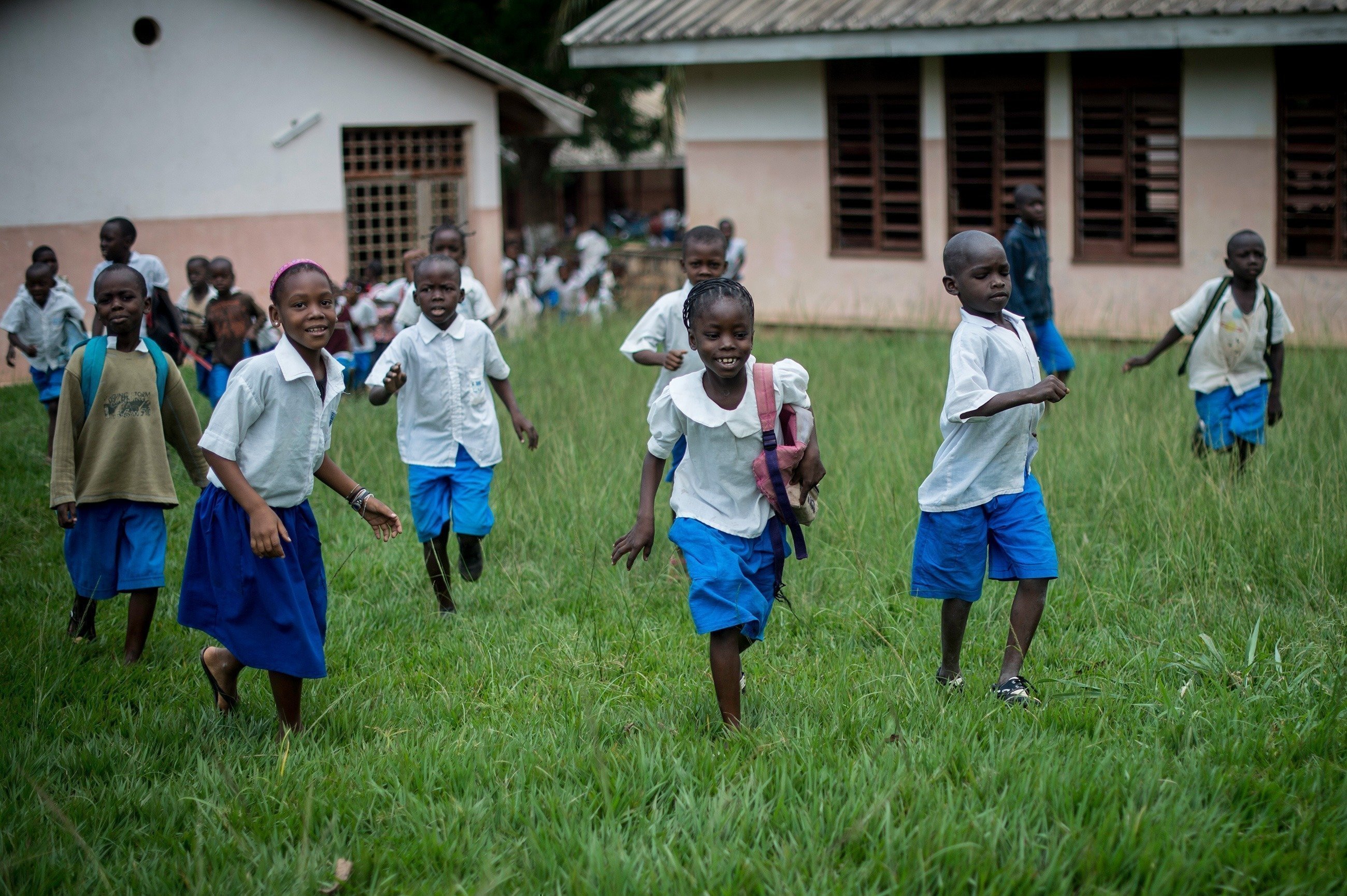 Kinder rennen nach Schulschluss aus der Schule raus.