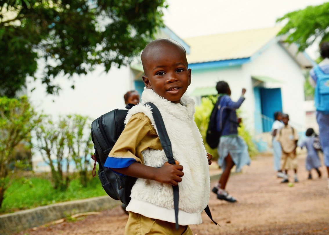 Bambino africano con zaino andando a scuola.