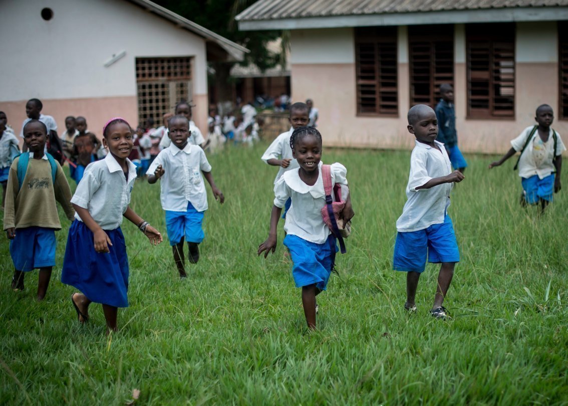 Bambini escono correndo dalla scuola al termine delle lezioni.
