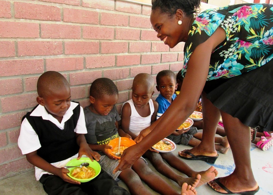 Una madre SOS dà da mangiare ai bambini.