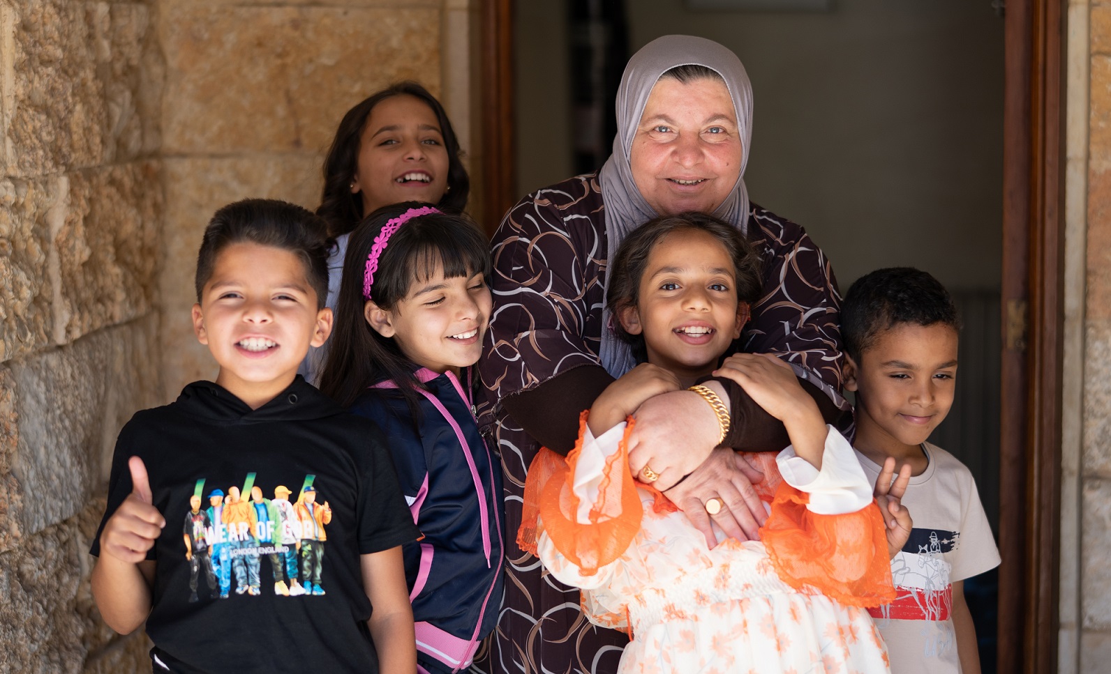 Malak, sullo sfondo a sinistra, la sua mamma SOS e i fratelli e le sorelle del villaggio dei bambini SOS di Irbid. © Martin Hanebeck